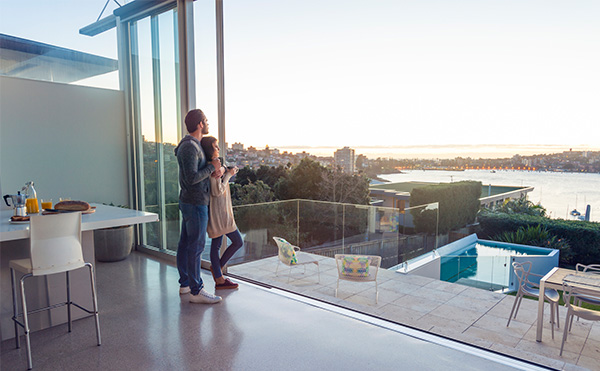 A couple together in a luxury home looking out over Sydney Harbour
